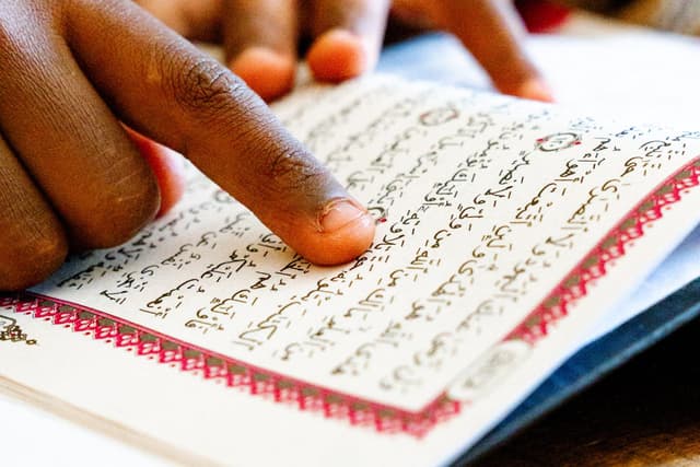Child reading Quran online, young student learning with female teacher