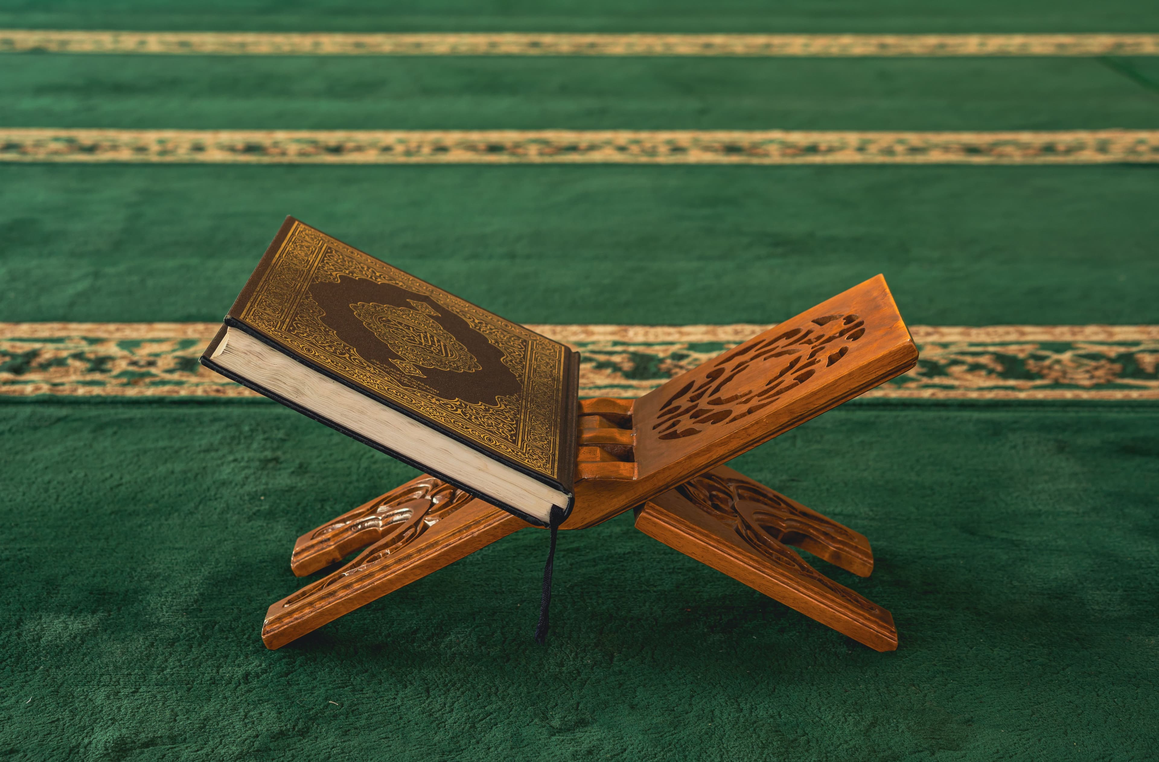 Hands holding an open Quran while reading