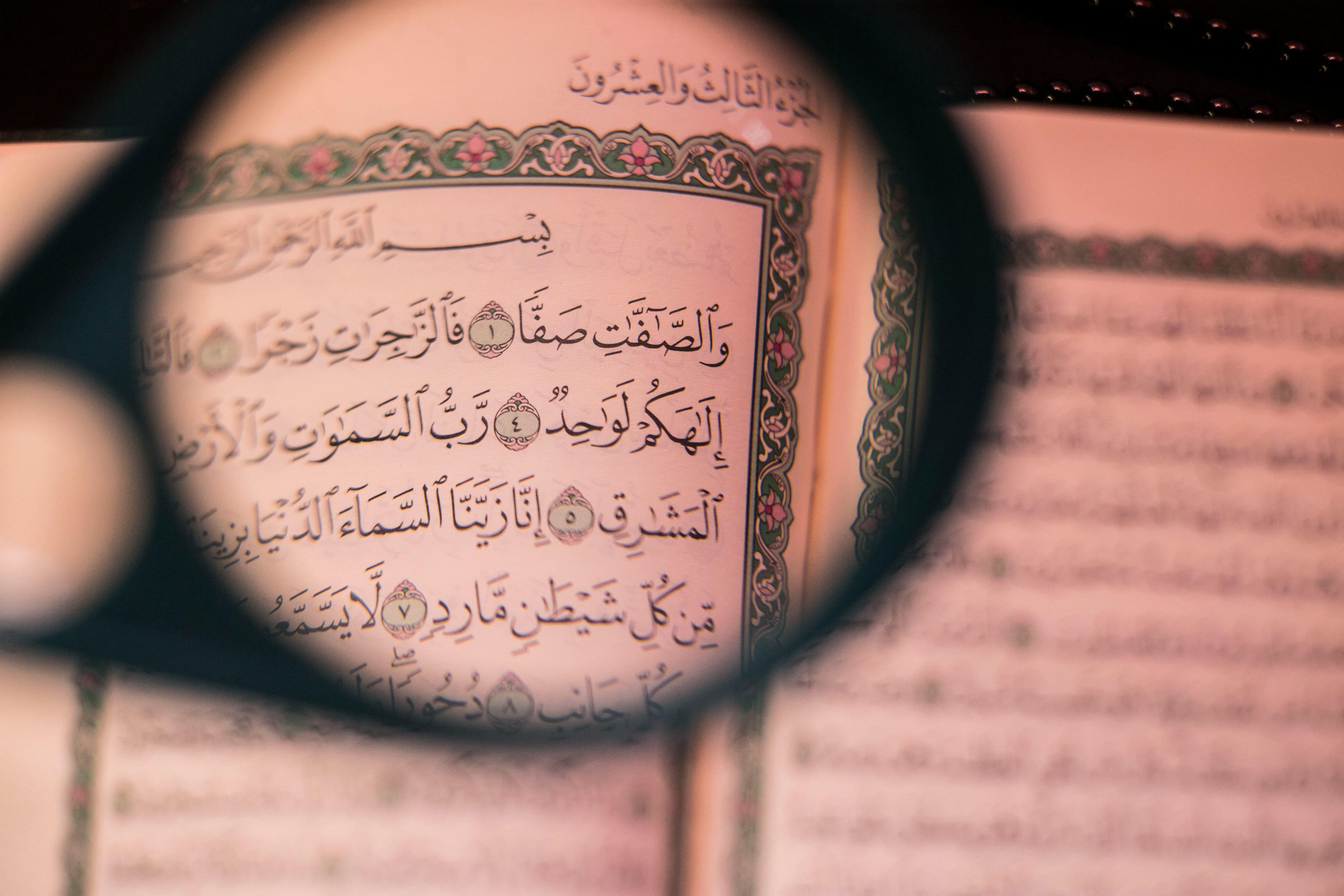 Close-up of fingers tracing Quran verses